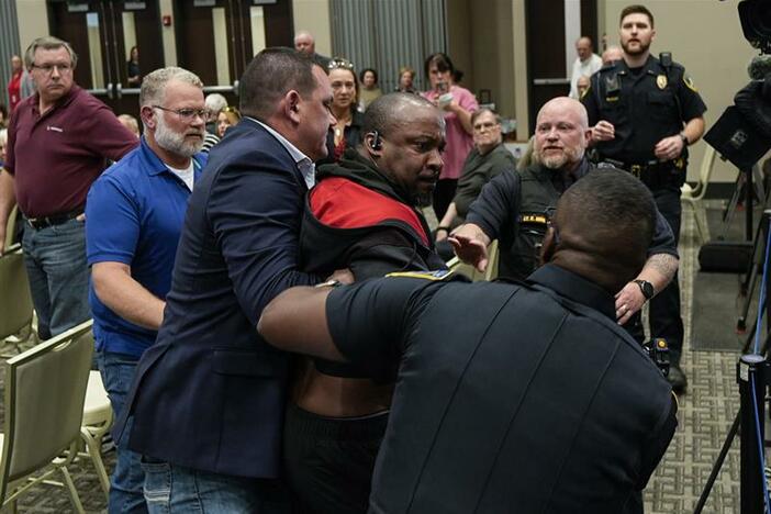 A protester is removed before a electronic non-leathal device was used as Rep. Marjorie Taylor Greene, R-Ga., speaks during a town-hall style meeting, Tuesday, April 15, 2025, in Acworth, Ga.