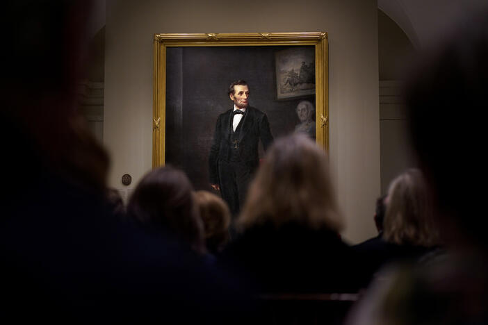 People gather for a ribbon cutting ceremony at the Smithsonian's National Portrait Gallery to announce the installation of a life-size painting of President Abraham Lincoln by artist W.F.K. Travers, Feb. 10, 2023, in Washington. 