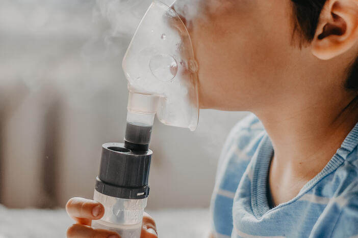Young child using nebulizer.