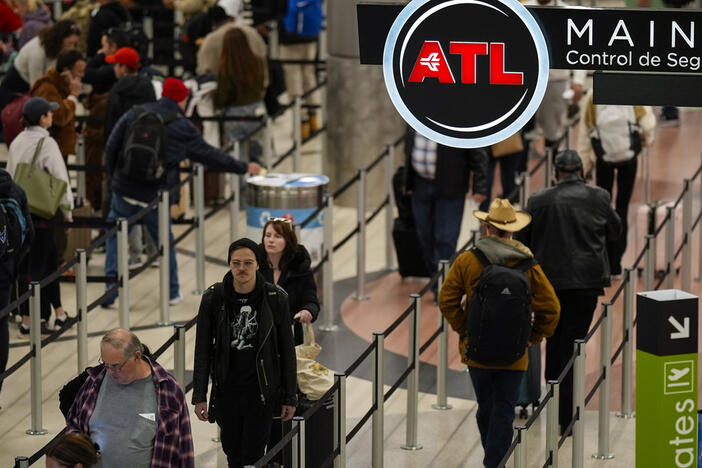 Travelers move through Hartsfield-Jackson Atlanta International Airport, Friday, Dec. 20, 2024, in Atlanta. (AP Photo/Mike Stewart)