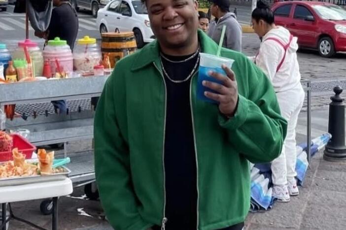Chris Allen Villegas Fentress is shown holding a blue drink in an outdoor location.