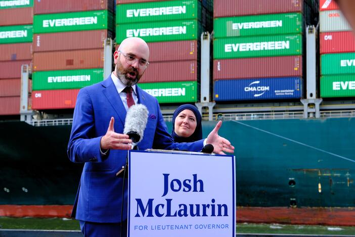 Georgia Sen. Josh McLaurin of Atlanta, standing next to Georgia Rep. Ruwa Romman of Duluth, announces his run for lieutenant governor along downtown Savannah's riverfront on Monday, May 5, as a container ship sails toward the Port of Savannah.