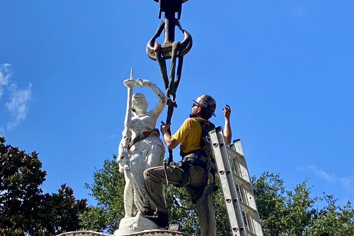 A worker attaches the Forsyth Park fountain's crowning statue onto a crane for removal on Monday, June 23.