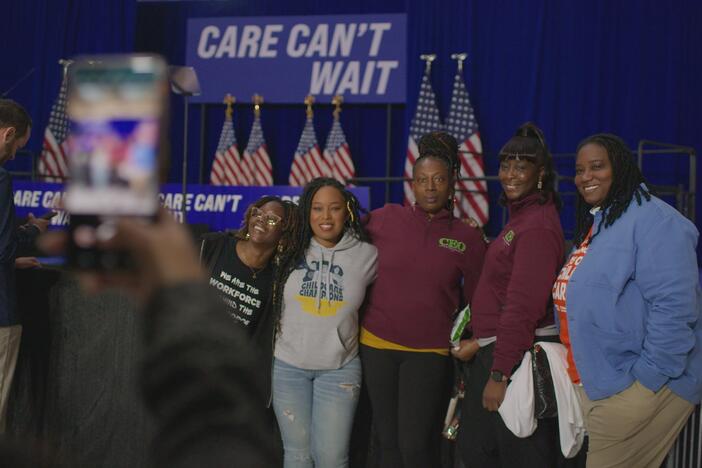 A group of Black women posing for a photo in front of a sign that says "care can't wait."