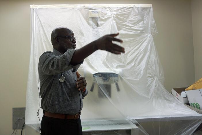 Dr. Alawode Oladele in front of a new X-ray machine that is part of DeKalb Public Health's new tuberculosis clinic. The county has the highest rate of TB infections among Georgia counties. (Rebecca Grapevine / Healthbeat)