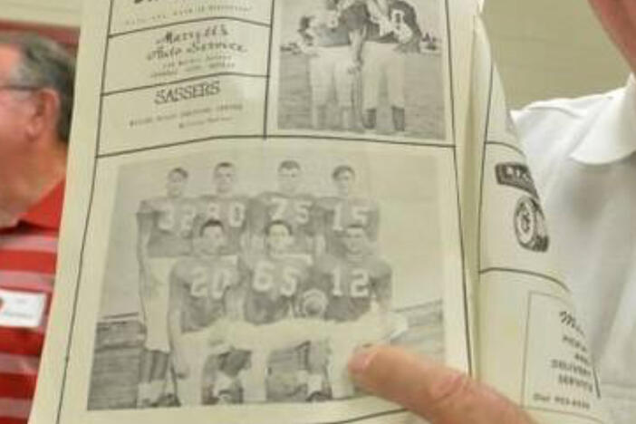 Perdue poses with photo of him during his football days.