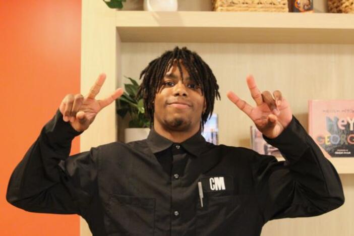 RJ is an intern with Cafe Momentum seen here giving the peace sign on each hand