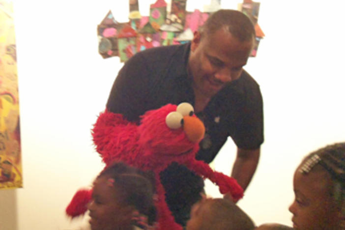 Elmo hobnobs with kids from Sheltering Arms at the science and arts education announcement.