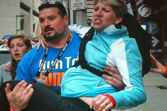 Former New Englands Patriot Joe Andruzzi helps a bombing victim.  Photo courtesy Twitter.