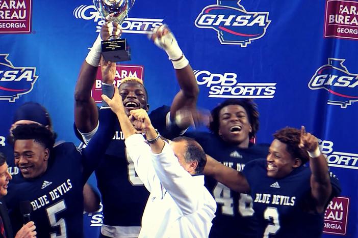 The Norcross Blue Devils hoist the 2013 Class AAAAAA state title trophy.