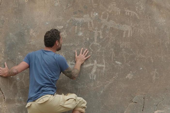Archaeologist Jeff Rose examines the history of a petroglyph in Oman.