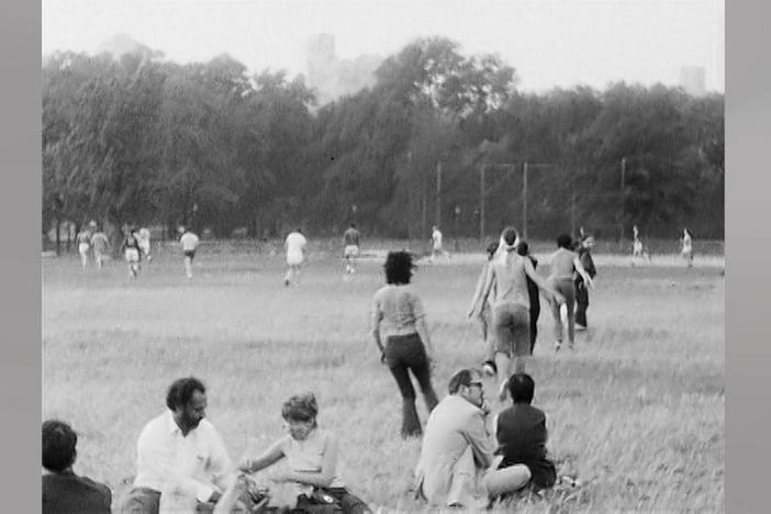 Archival footage shows one of Twyla Tharp's dances in Central Park amongst the public.