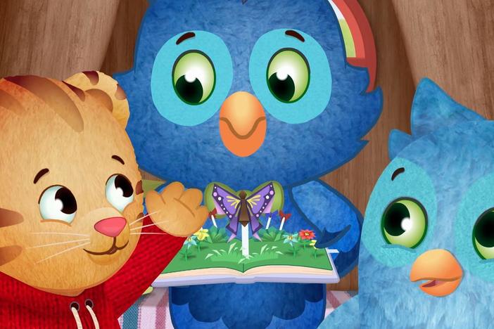 O and Daniel read the pop-up book with X.