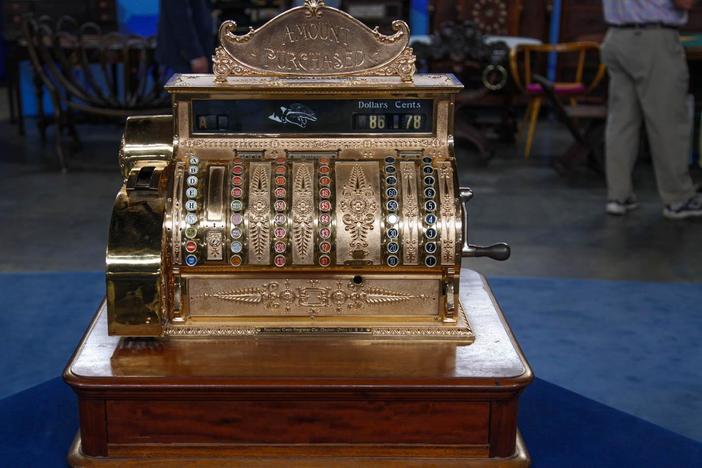 Ken Farmer appraises a National Cash Register brass cash register.
