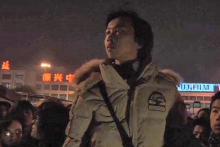 The Zhangs and other workers complain to the police at the train station.