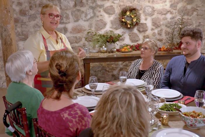 At the celebratory feast in PA, Lidia makes a toast and listens to an opera singer.