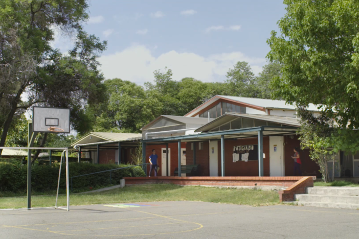 Starts with Anita saying, “Hello,” and boarding the bus to her school.