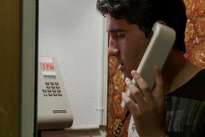 Ehsanullah speaks on the phone with his family in Afghanistan.