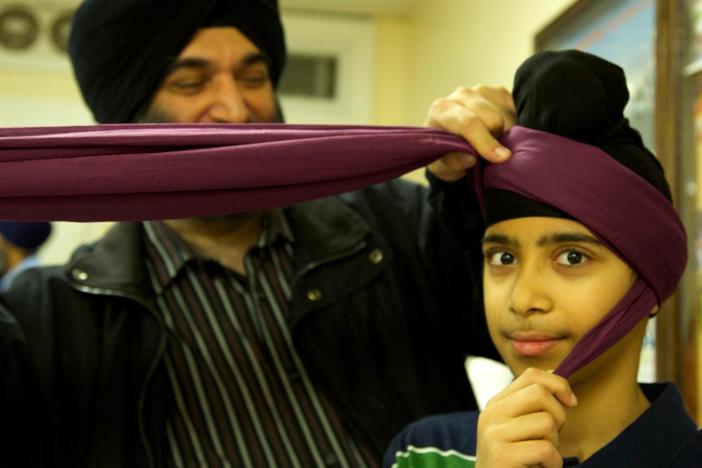 Children learn to tie their turbans for the first time.