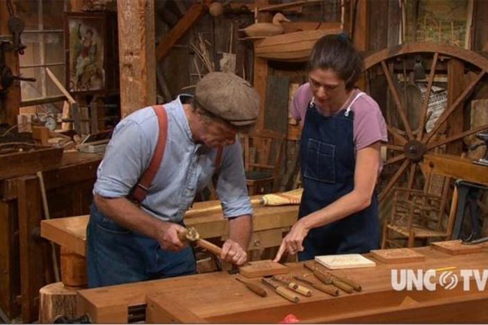 Woodcarver Mary May gives Roy Underhill his first lessons in floral carving. 