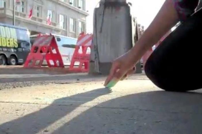 Carla Orendorff films her fellow Student Riders writing messages on the sidewalk in chalk.