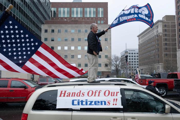 Crowds gather to protest restrictions, but health experts issue grim warning