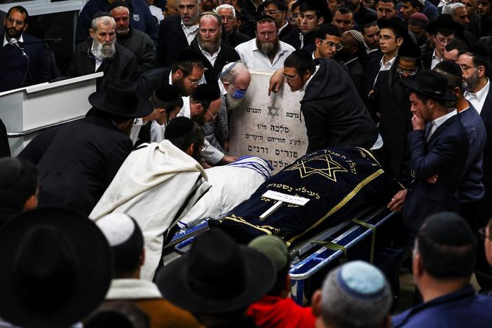News Wrap: Israel holds funerals for victims of synagogue shooting
