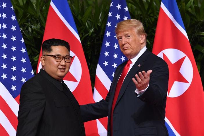 Trump and Kim begin historic summit with cordial greeting