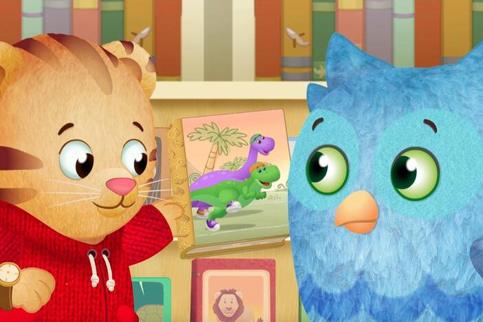 Daniel shares a book with O the Owl. / Daniel gets a special sticker book from Grandpere.