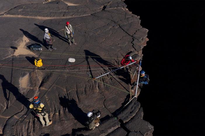 Steve and team examine the lava tube opening to identify a stable entry point.