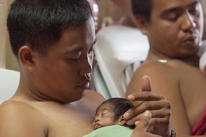 Visiting fathers hold their babies against their bodies, a method for keeping the ...