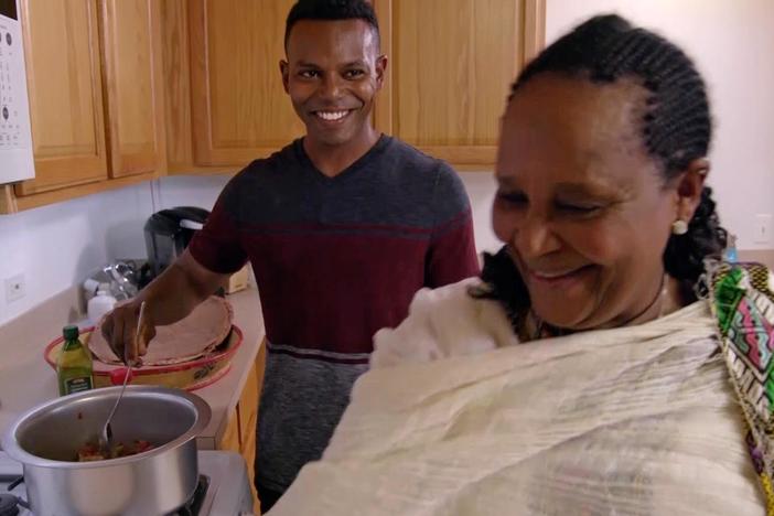 Lidia talks and eats with retired army staff sergeant Yonas Hagos, and his mother.