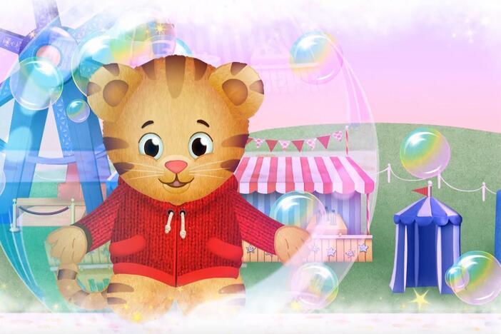 Daniel makes believe he is inside a bubble floating in the air over the carnival.