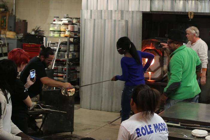 Therman Statom collaborates with students to make a glass head at Hot Shops Art Center.