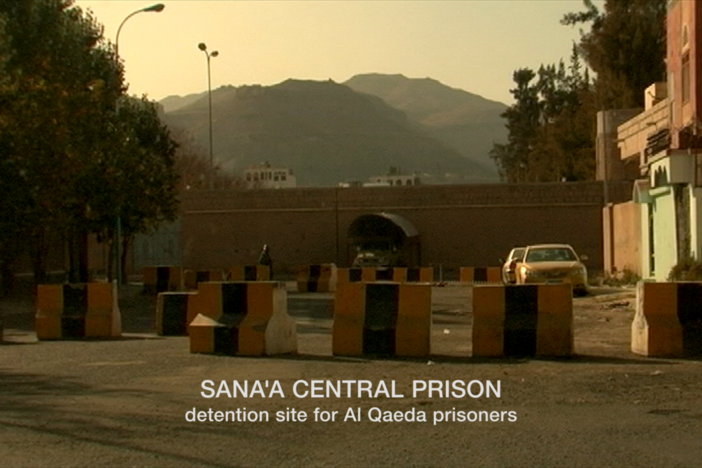 Johnson's driver informs her that journalists need a permit to shoot video of the prison..