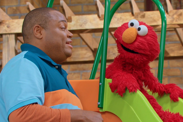 Elmo is feeling excited and a little scared to go down the big slide for the very first time.