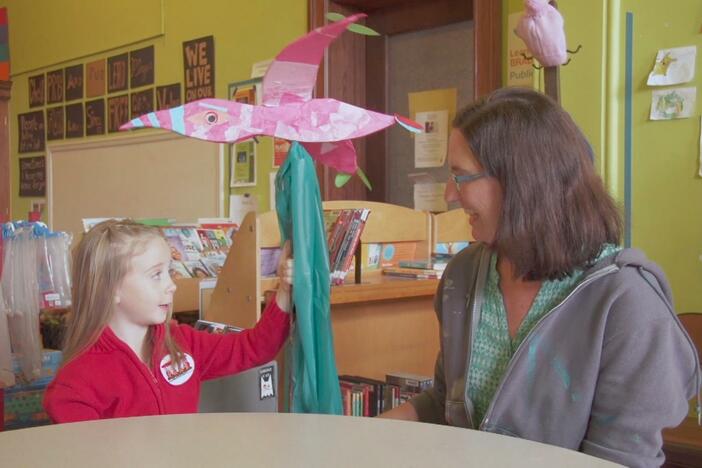 Ryan is at the library where she learns how to make a puppet. 