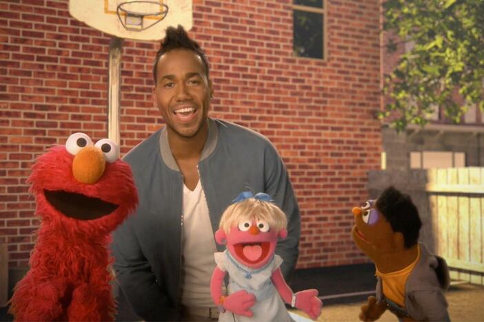 Romeo Santos and Elmo sing about making friends.