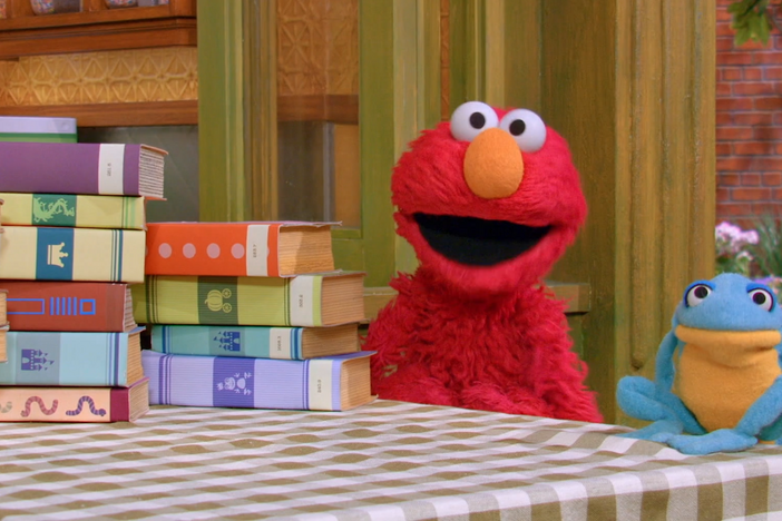 Librarian Grover helps Nina and Elmo find the books they need in different sections of the library.