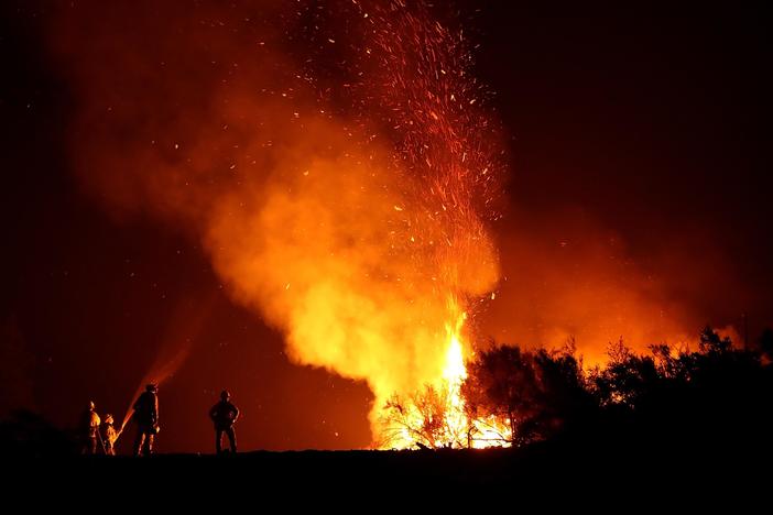 Massive California wildfires displace thousands of residents and affect air quality.