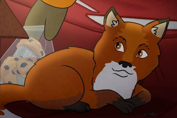 Molly warms her feet in the sled bag, but there's something fuzzy in it? It's a baby fox!