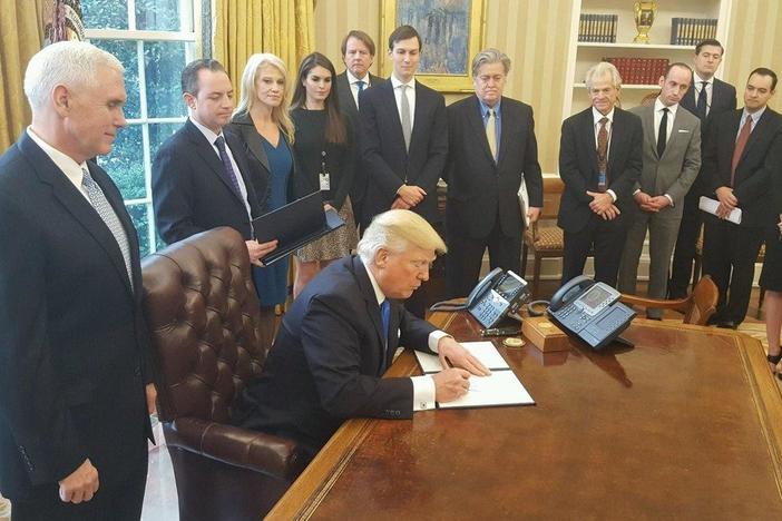Trump signs executive order freezing refugee visas from predominantly Muslim countries.
