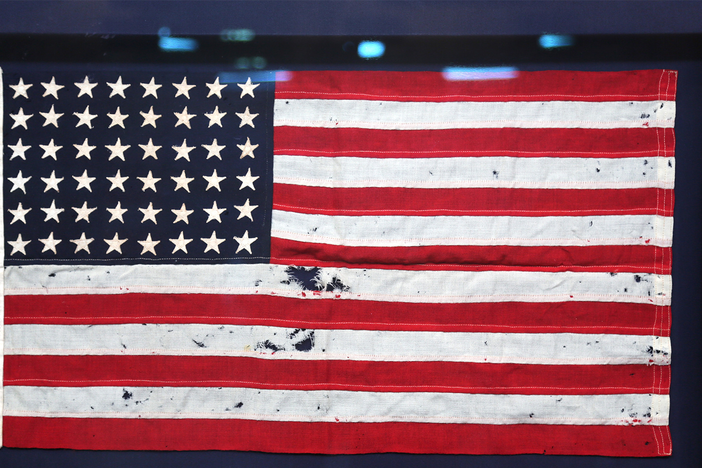 Jeff Shrader appraises a U.S. flag that might be from JFK's WWII vessel, PT-109.
