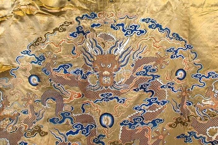 James Callahan appraises a Chinese Imperial dragon brocade.