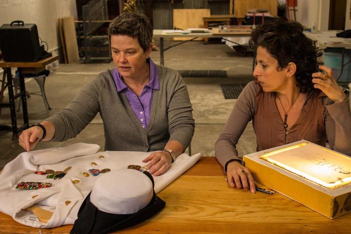 U.S. Navy veteran Kelly McFarland explains the details of a Chief Petty Officer's uniform.