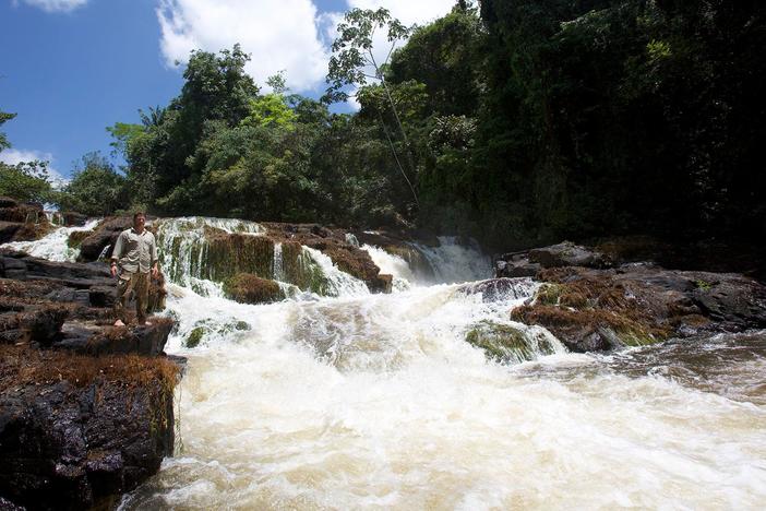 The team celebrates when they come across an immense waterfall on the river.