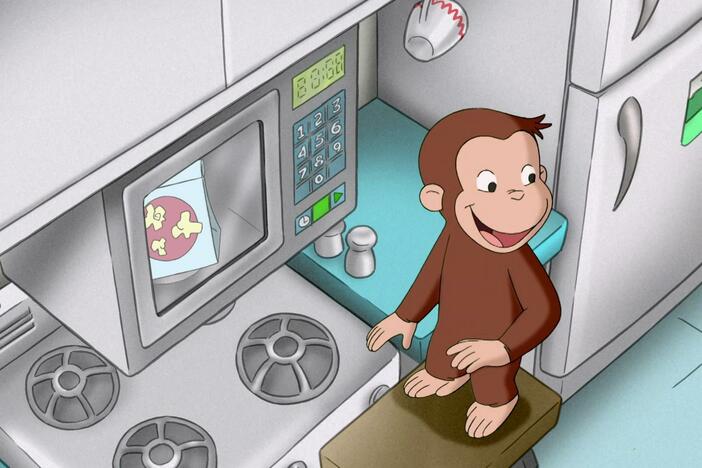 George has fun pushing buttons on the microwave.