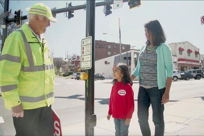 A crossing guard helps take care of children when they cross the street. 
