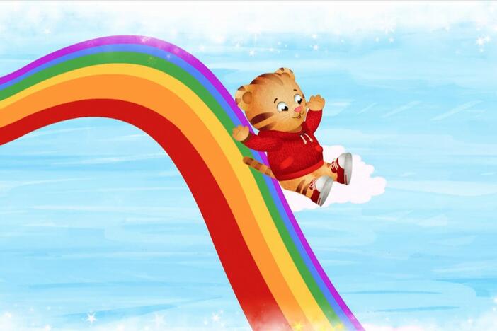 Daniel make believes he is a rainbow world where he slides down a giant rainbow.  