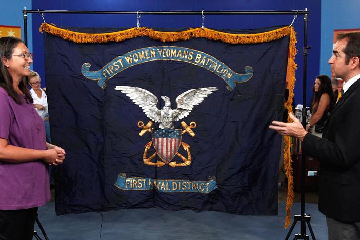 Gary Piattoni appraises a 1917 First Women Yeomans Battalion flag.